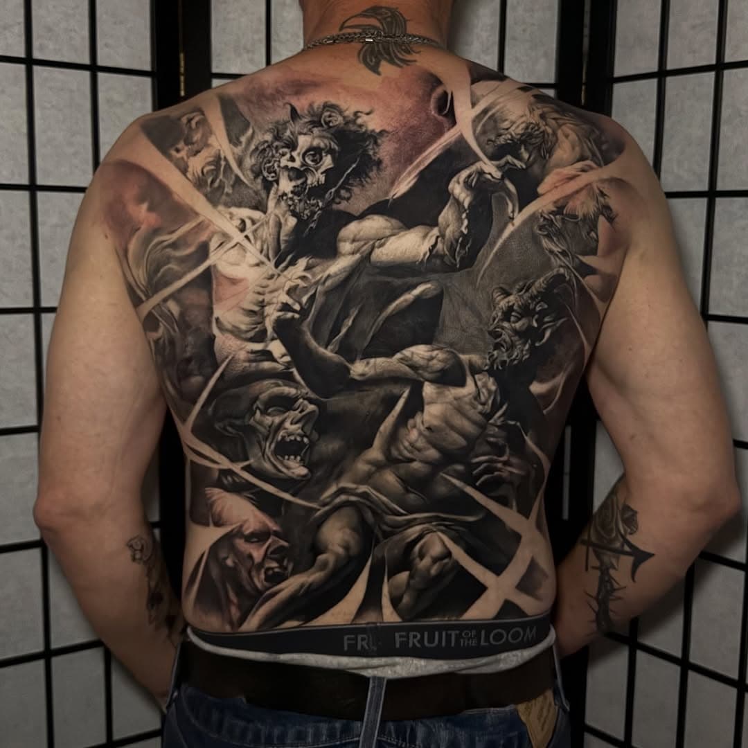 Finished full back cover-up in black and grey, with falling figures and creatures composed over previous tattoos.