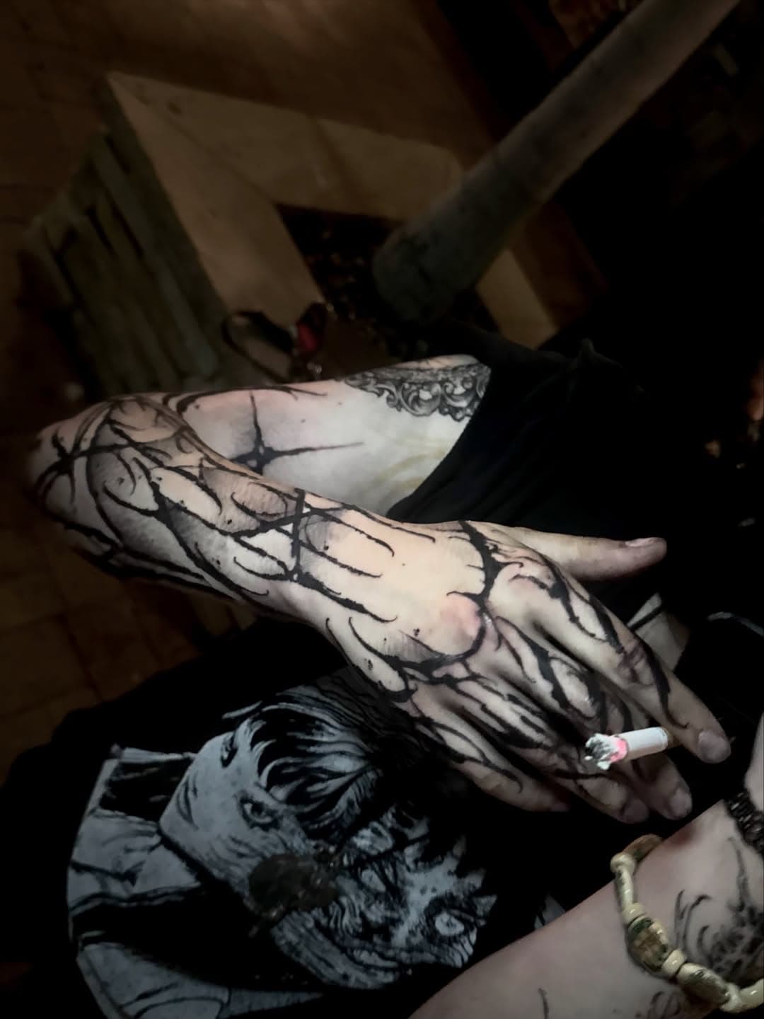 First session of a gothic blackwork sleeve continuing across the back of the hand and fingers in branching black strokes.